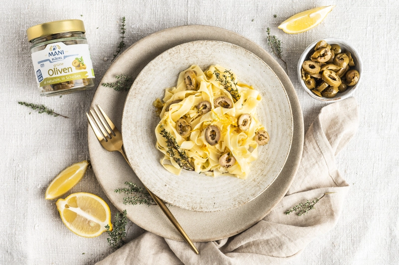 Zitronenpasta auf dem Teller angerichtet mit MANI Oliven